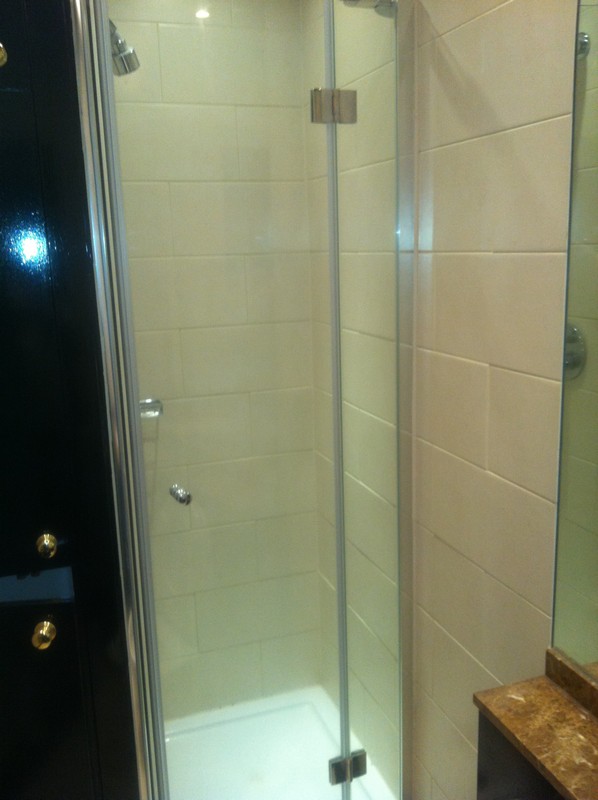 Frameless glass shower enclosure with chrome fittings in Wolverton